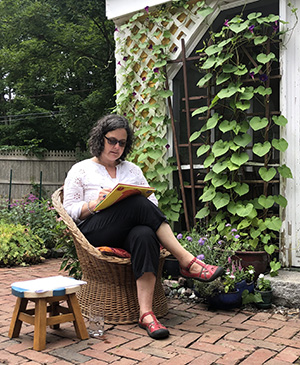 Beatrice Chrystall reading in her garden