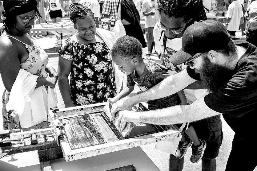 Rev. Erik and artists at The Sanctuaries help residents screenprint wearable protest art