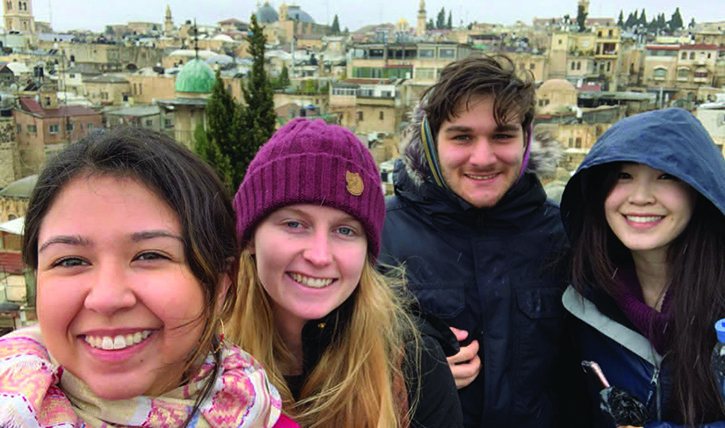 Participants in the Religion, Conflict, and Peace 2020 J-term course, including Yaseen Hashmi, MTS ’21 (second from right), pose in front of the skyline of the Old City of Jerusalem.