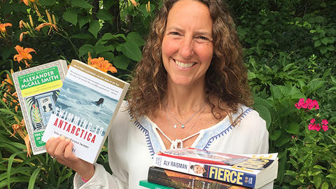 Michelle Goldhaber holding up a stack of books